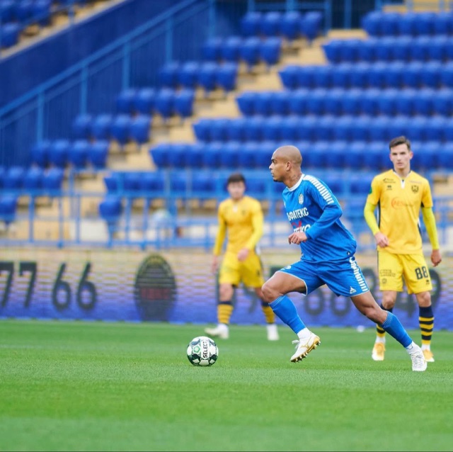 Jonathan ZJ conduzindo a bola de uniforme azul